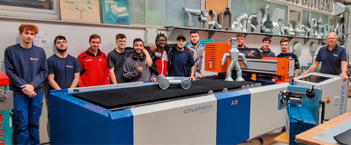 Schulung mit der computergesteuerten Zuschneideanlage des Ausbildungszentrums (Ulrich Büringer, rechts).