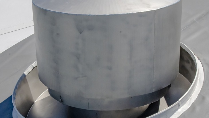 „Nahaufnahme eines großen, runden Metalllüftungskanals auf einem Flachdach, ausgestattet mit moderner Dämmlösung für optimalen Wärme- und Schallschutz in industriellen Anwendungen. - © Bohle Gruppe/T.Elger elgerart.de „Nahaufnahme eines großen, runden Metalllüftungskanals auf einem Flachdach, ausgestattet mit moderner Dämmlösung für optimalen Wärme- und Schallschutz in industriellen Anwendungen. - © Bohle Gruppe/T.Elger elgerart.de