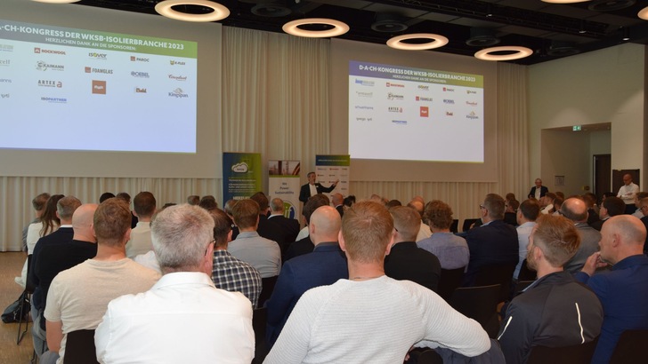 „Fachpublikum bei einer Konferenz über innovative Dämmstoffe und Energieeffizienz in der Gebäudetechnik, mit Vortragsszenen und Logodarstellungen führender Branchenakteure. - © RM Rudolf Müller Medien GmbH & Co. KG „Fachpublikum bei einer Konferenz über innovative Dämmstoffe und Energieeffizienz in der Gebäudetechnik, mit Vortragsszenen und Logodarstellungen führender Branchenakteure. - © RM Rudolf Müller Medien GmbH & Co. KG