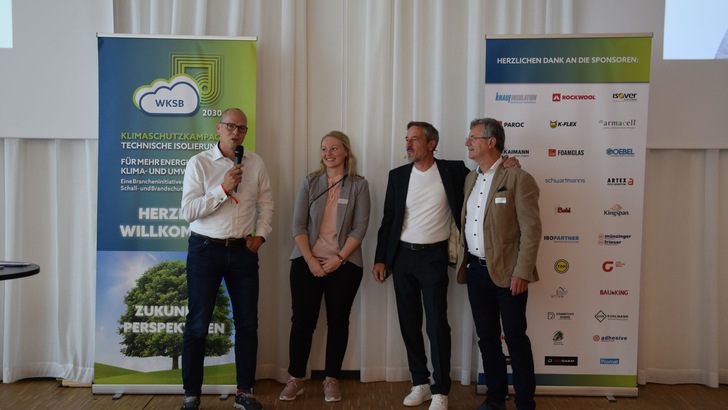 „Vier Fachleute aus der Bau- und Dämmstoffbranche diskutieren auf einer Bühne über innovative Lösungen in der technischen Isolierung vor einem Hintergrund mit Bannern und Sponsorenlogos.“. - © RM Rudolf Müller Medien GmbH & Co. KG „Vier Fachleute aus der Bau- und Dämmstoffbranche diskutieren auf einer Bühne über innovative Lösungen in der technischen Isolierung vor einem Hintergrund mit Bannern und Sponsorenlogos.“. - © RM Rudolf Müller Medien GmbH & Co. KG