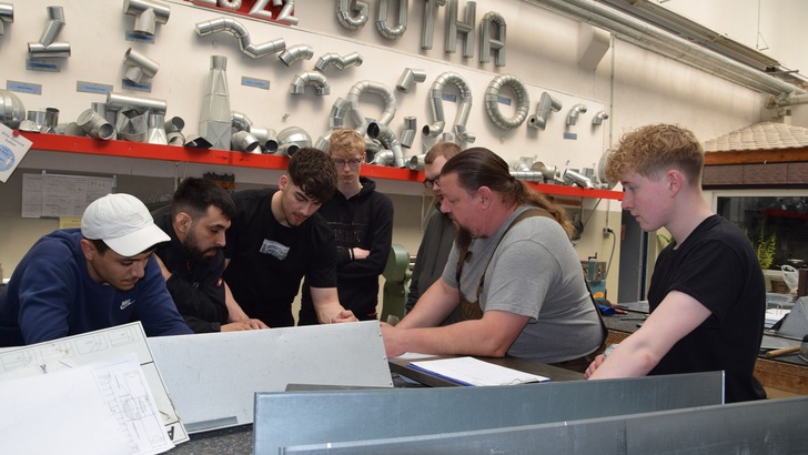 Hausaufgabenbesprechung der Auszubildenden im 1. Lehrjahr mit Michael Hempe,  Meister für WKSB-Isolierung und Fachausbilder WKSB-Isolierer am ABZ Bau Gotha. (v.l.n.r. Abdelkarim Akrouni, Adib Mariami, Armin Reza Zarghami, Leon Eifart, Jan Söhnel, Michael Hempe, Phil Oxfort)