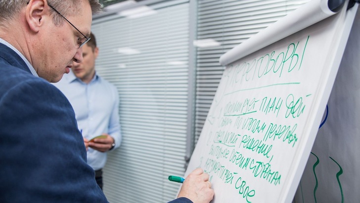 „Zwei Männer bei einer Präsentation zur technischen Dämmung; einer der Männer schreibt mit einem grünen Marker auf einem großen Flipchart in kyrillischer Schrift über innovative Dämmstoffe und Energieeffizienzlösungen. - © dmitrymotorin auf Pixabay