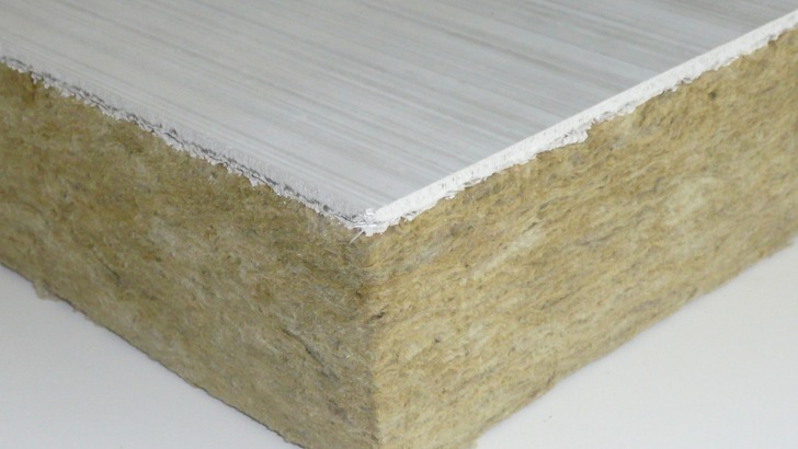 „Nahaufnahme eines technischen Dämmplattenabschnitts mit faseriger, strukturierter Isolationsschicht und glatter, weißer Oberflächenbeschichtung für verbesserte Energieeffizienz und Schallschutz. - © Rockwool