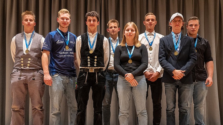 Siegerin und Sieger der 72. Deutschen Meisterschaften im Bauhandwerk von links: Florian Quade (Maurer), Philipp Schlegel (Fliesenleger), Florian Dorer (Zimmerer), Franz Lehnert (Stuckateur), Jacqueline Baden (Wärme-, Kälte-, Schallschutzisoliererin), Julius Erfurth (Straßenbau), Muhammed Ali Lamain (Beton-Stahlbetonbau), Nils Schneider (Estrichleger). Der Deutsche Meister der Brunnenbauer, Tjard Beth, fehlt auf dem Foto, da der Wettbewerb in Bad Zwischenahn stattfand. © Petra Reidel.  Petra Reidel)