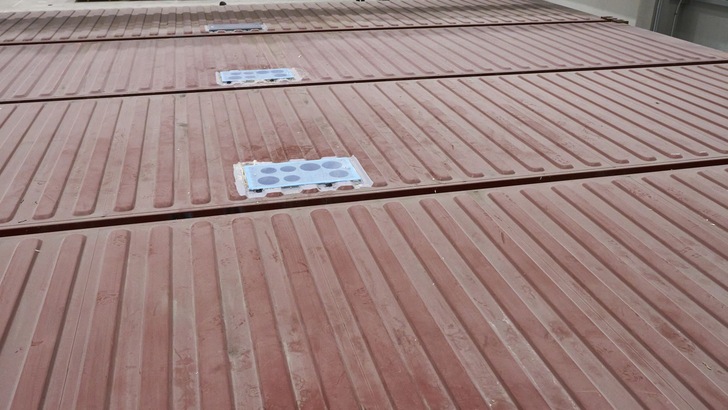 Die Container für das TIN INN Montabaur kurz vor ihrer „Abreise“ in der Montagehalle der Containerwerk eins GmbH: Die Abschottungselemente aus CLT-Holzplatten mit den vorbereiteten Kernbohrungen sind in die Decken der Container eingesetzt und für den Transport abgedichtet.