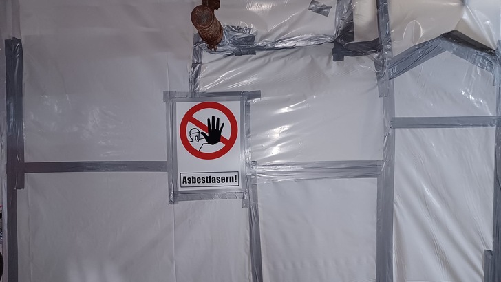 Asbestsanierung: Der zu sanierende Schwarzbereich ist von der Umgebung streng getrennt.