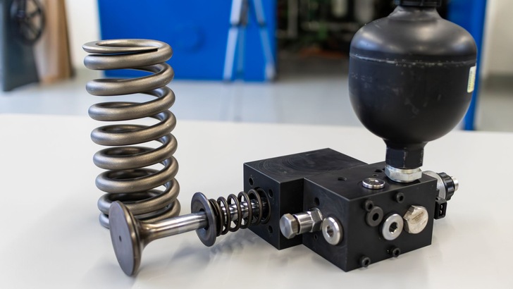 Der elektrohydraulische Ventilaktuator, das Herzstück der Maschine, mit der dazugehörigen Ventilfeder im Hintergrund.