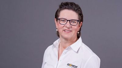 Person mit kurzen Haaren und Brille, lächelnd, trägt ein weißes Hemd mit „Isover“-Logo vor einem grauen Hintergrund. - © Peggy Schröer