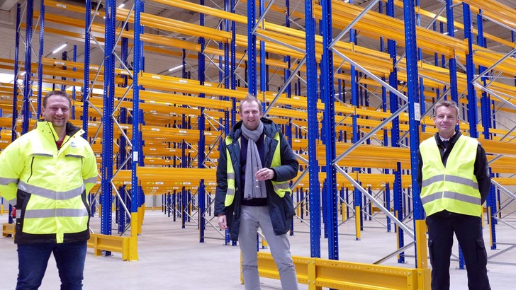 Hagebau-Logistikchef Gerritt Höppner-Tietz steht mit Gästen in einer Lagerhalle.