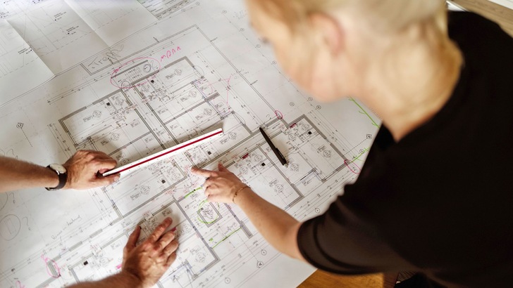 Personen diskutieren Gebäudepläne