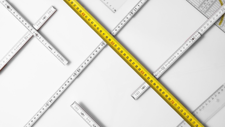 Zollstöcke und Maßbänder übereinandergelegt