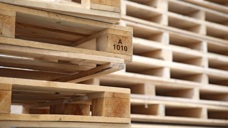 mehrere Holzpaletten, gestapelt, mit Aufdruck großes A