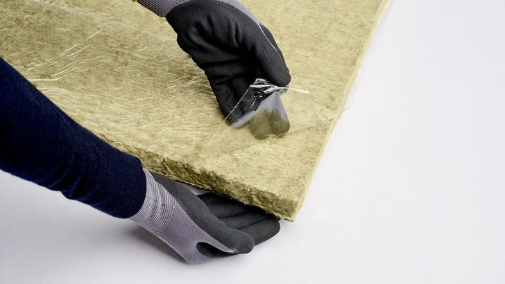 Die Lamellenmatte „Teclit LM Cold EF“ ist „Easy Fit“: einfach die Schutzfolie von der selbstklebenden Beschichtung auf der Rückseite der Matte abziehen und Dämmung auf dem Stahlblechkanal festdrücken. Diffusionsdicht verschlossen wird mit den „Teclit“ Klebebändern. - © Deutsche Rockwool GmbH & Co. KG