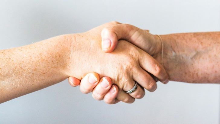 Zwei Menschen reichen sich die Hand