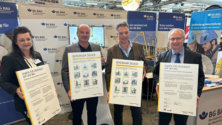 Peggy Ruchatz, Branchenkoordinatorin in der Hauptabteilung Prävention der BG BAU, Johannes Schlenter, Vorstandsvorsitzender des Deutschen Abbruchverbandes, Bernd Pagel, Mitarbeiter im Referat Tiefbau der Hauptabteilung Prävention der BG BAU und Andreas Pocha, Geschäftsführer des Deutschen Abbruchverbandes, präsentieren die unterzeichnete „Charta für Sicherheit auf dem Bau“ sowie das Bekenntnis „Gemeinsam sicher“