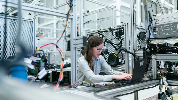 Frau an Laptop in Industrieumgebung - © Unsplash, Thisisengineering