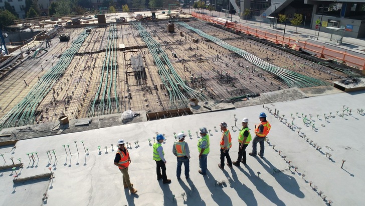 Blick auf eine Baustelle, an der mehrere Arbeitende stehen - © Unsplash, Scott Blake