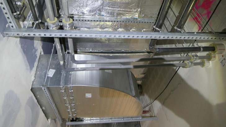 Bild 1: Eckige Luftleitung, bei der eine Lamellenmatte mit sechs Stiften befestigt ist, die Matte dahinter ist ohne mechanische Befestigung montiert. Deutlich ist das „Durchhängen“ der nur geklebten Matte erkennbar.