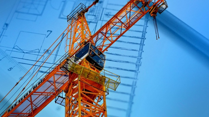 Bildmontage eines Krans vor einem Bauplan