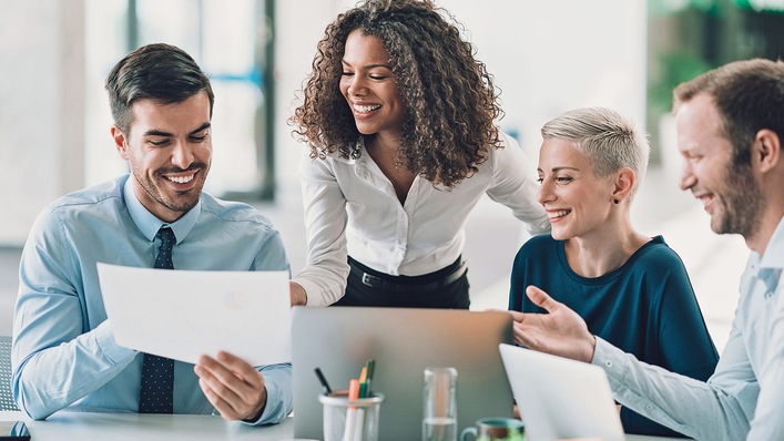 Szene in einem Büro, lächelnde KollegInnen