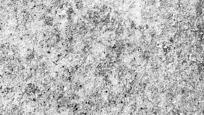 Eine Nahaufnahme einer rauen Betonoberfläche mit sichtbaren Texturen und Unregelmäßigkeiten.